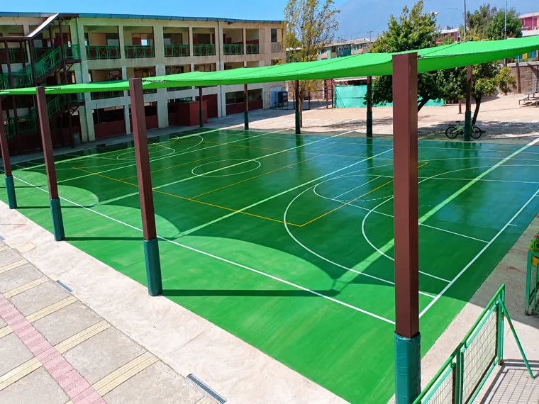 Cancha deportiva junto a edificio educacional