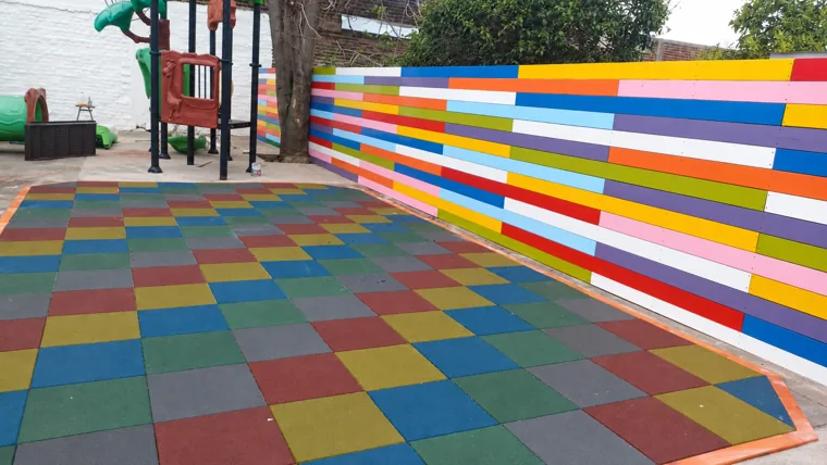 Patio infantil con pavimento y muro de colores